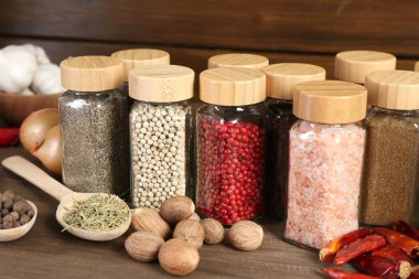 Farklı baharatlar ve kavanozlar ahşap masada, yakın plan