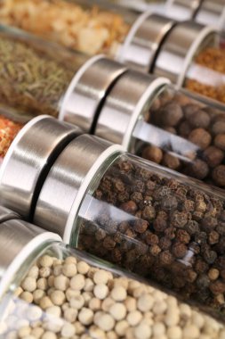 Arka plan olarak cam kavanozlardaki farklı baharatlar, yakın plan