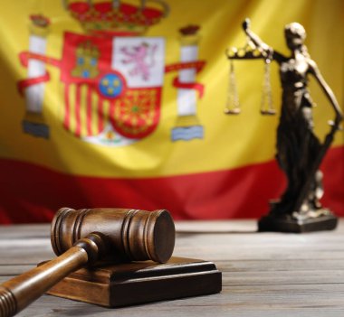 Hakimin tokmağı ve heykeli tahta masada İspanya bayrağına karşı, yakın plan.