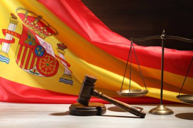 Hakimin tokmağı ve pulları tahta masada İspanya bayrağına karşı