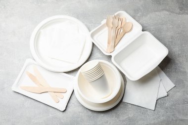 Tek kullanımlık sofra takımı ve peçeteler gri masada, düz yatıyordu.