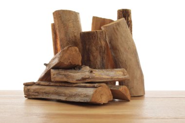 Ahşap masa üzerine kesilmiş odun yığını beyaz arka plana karşı