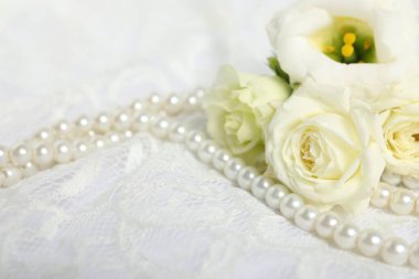 Beautiful flowers and pearls on lace fabric, closeup