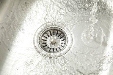 Water going down sink drain, closeup view