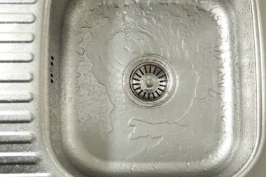 Water going down sink drain, top view