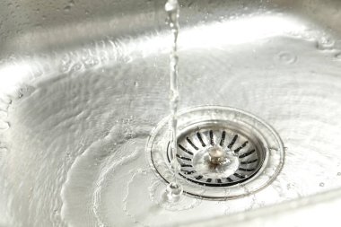 Water going down sink drain, closeup view