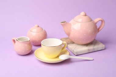 Menekşe arka plandaki çocuklar için güzel seramik çay seti, yakın plan.