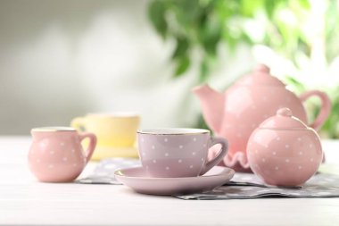 Beyaz ahşap masadaki çocuklar için seramik çay seti bulanık arka plan, yakın plan