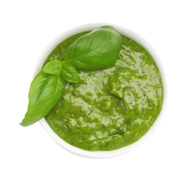 Pesto sauce with basil leaves in bowl isolated on white, top view