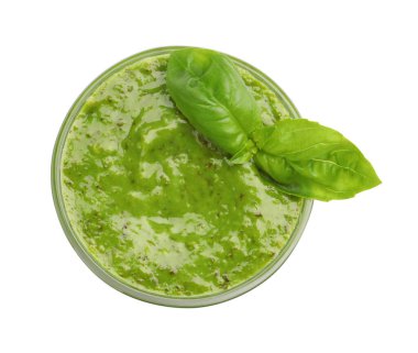 Pesto sauce with basil leaves in bowl isolated on white, top view
