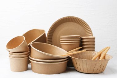 Tek kullanımlık sofra takımını beyaz döşemeli masaya koyun.