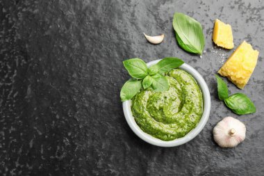 Taze pesto sosu ve siyah desenli masa üzerindeki malzemeler. Metin için boşluk