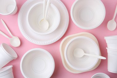 Pembe arka planda tek kullanımlık plastik sofra takımı, düz konum