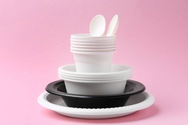 Pembe arka planda tek kullanımlık plastik sofra takımı, yakın plan