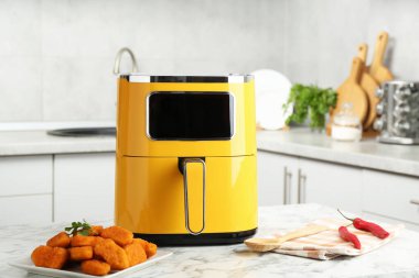 Mutfaktaki beyaz mermer masada tavuklu kızartma ve kızarmış tavuk nugget.