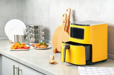 Kızartma makinesi ve pişmiş tavuk mutfakta tezgahta.