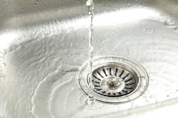Water going down sink drain, closeup view