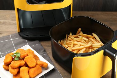 Kızarmış patates kızartması ve tavuklu nugget ile ahşap masada, yakın plan.