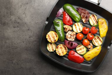 Gri masada ızgara sebze ve baharatlı tava, üst manzara. Metin için boşluk