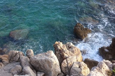 Sea with clean water and stones on shore in summer, above view