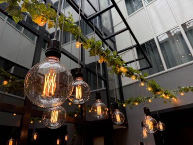 Ampuller açık terastaki kablolarda asılı, düşük açı manzaralı.