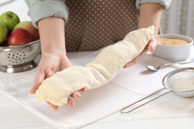 Mutfaktaki beyaz ahşap masada nefis elmalı turta yapan kadın.