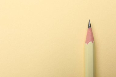 Bej arka planda keskin bir grafit kalem, üst manzara. Metin için boşluk