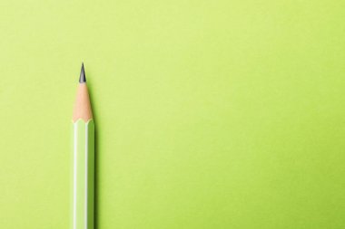 Açık yeşil zemin üzerinde keskin bir grafit kalem, üst görüş. Metin için boşluk