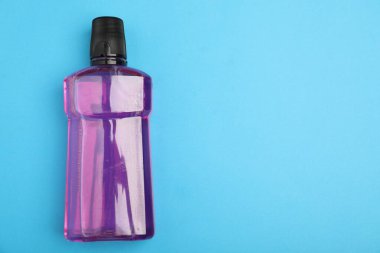 Açık mavi arka planda bir şişe gargara, üst manzara. Metin için boşluk