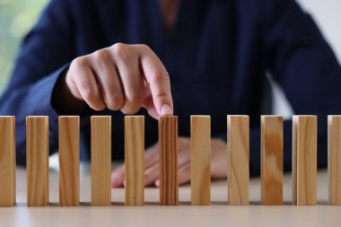 Risk. Kadın masadaki domino masasını işaret ediyor, yakın plan.