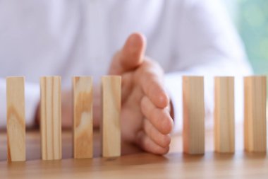 Risk. Tahta masada domino efektini durduran adam, yakın plan.