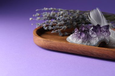 Güzel ametist mücevher, mor arka planda tüy ve lavanta çiçekleri, yakın plan. Metin için boşluk