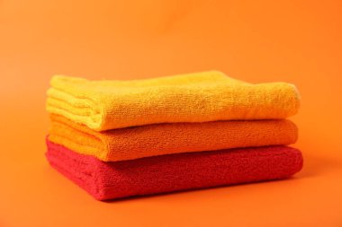 Turuncu arka planda bir yığın temiz havlu.