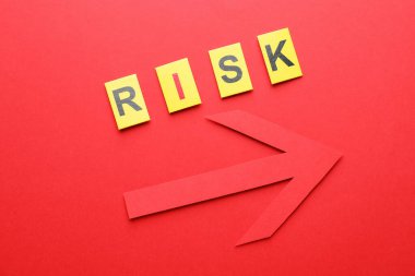 Kırmızı arkaplanda kelime riski ve ok, düz yatıyordu