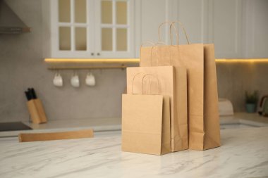 Mutfaktaki beyaz mermer masada kağıt torbalar. Metin için boşluk