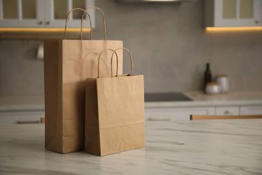 Mutfaktaki beyaz mermer masada kağıt torbalar. Metin için boşluk