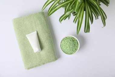 Taze havlu, kozmetik ürünler ve beyaz arka planda bitki.