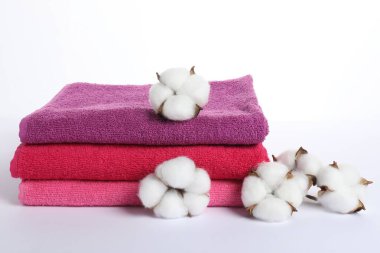 Bir yığın taze havlu ve pamuk çiçekleri beyaz üzerine izole edilmiş.