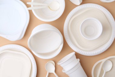 Bej arka planda tek kullanımlık plastik sofra takımı, düz konum