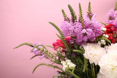 Pembe arka planda bir sürü güzel çiçek, yakın plan. Metin için boşluk