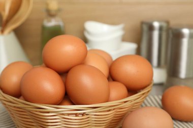 Hasır sepetteki çiğ tavuk yumurtaları tezgahın üstünde, yakın plan.