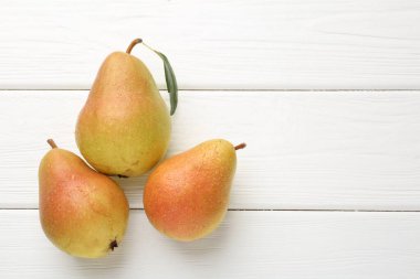 Taze olgun armutlar beyaz ahşap masada, düz yerde. Metin için boşluk