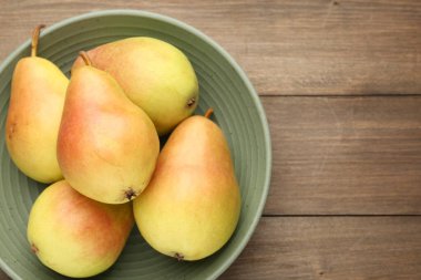 Tahta masanın üstünde taze armutlar, üst manzara. Metin için boşluk