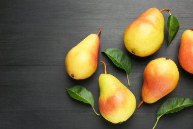 Siyah masanın üzerinde bir sürü taze armut ve yaprak vardı. Metin için boşluk