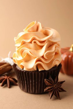 Renkli kremalı lezzetli kek, anason yıldızları, tarçın ve bej arka planda dekoratif balkabağı, yakın plan