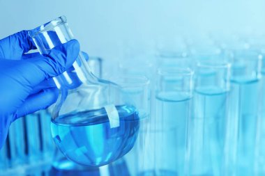 Laboratory analysis. Scientist holding flask, double exposure with test tubes
