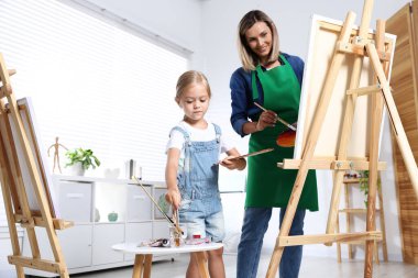 Meslek seçimi. Anne kızına stüdyoda resim yapmayı öğretiyor.