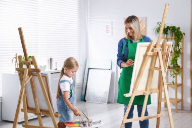 Meslek seçimi. Anne kızına stüdyoda resim yapmayı öğretiyor.