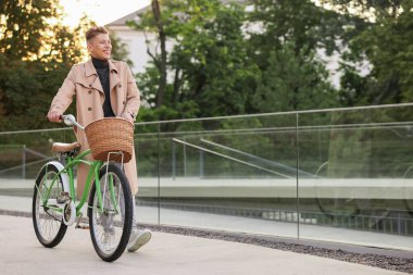 Şehir caddesinde bisikletini gezdiren mutlu bir adam. Metin için boşluk