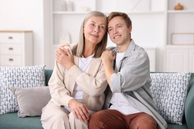 Mutlu oğul ve annesi evdeki kanepede.